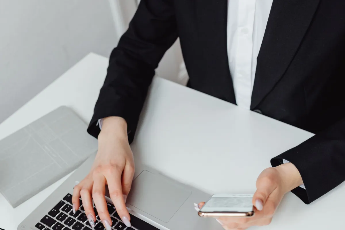 Employee working in Microsoft 365 on a laptop and smartphone